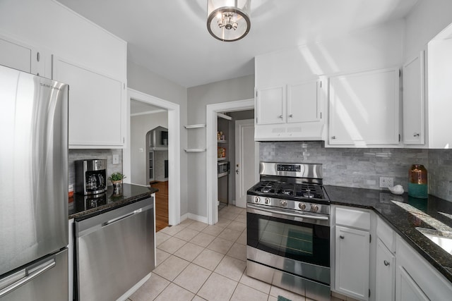 kitchen featuring appliances with stainless steel finishes, ventilation hood, tasteful backsplash, and white cabinets
