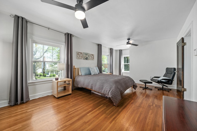 bedroom with ceiling fan, baseboards, and light wood-type flooring