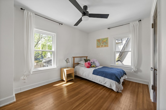 bedroom featuring a ceiling fan, baseboards, and hardwood / wood-style flooring