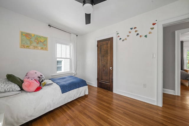 bedroom with baseboards, a ceiling fan, and wood finished floors