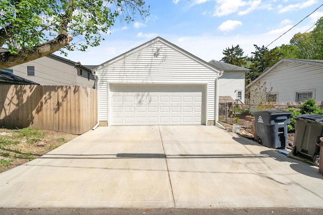 garage featuring fence and driveway