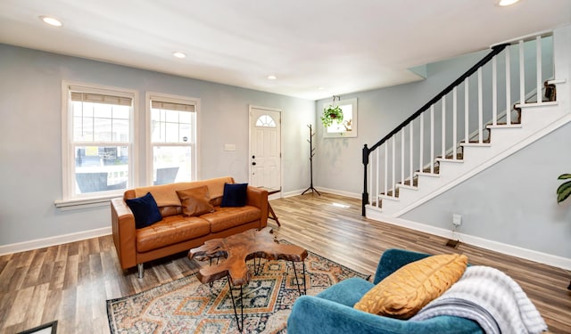 living room with recessed lighting, baseboards, wood finished floors, and stairway