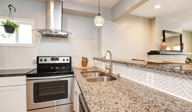 kitchen with stainless steel range with electric cooktop, a sink, wall chimney exhaust hood, white cabinetry, and tasteful backsplash