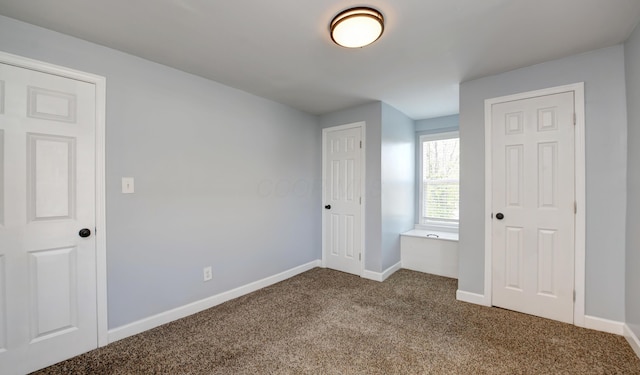 unfurnished bedroom with baseboards and dark colored carpet
