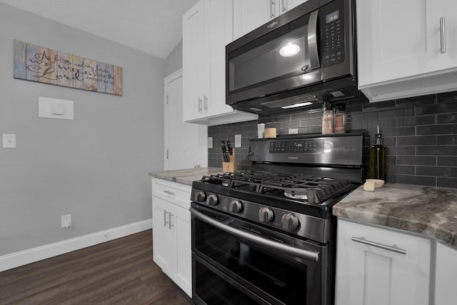 kitchen with backsplash, range with two ovens, baseboards, and white cabinets