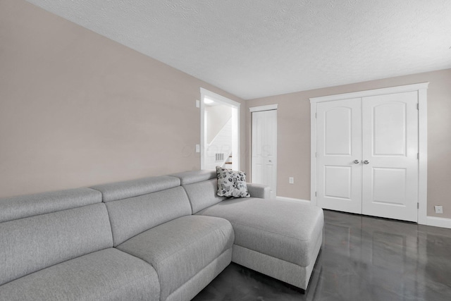 living room with a textured ceiling, baseboards, visible vents, and stairway