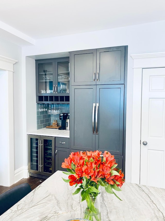 bar featuring wine cooler, baseboards, and a bar