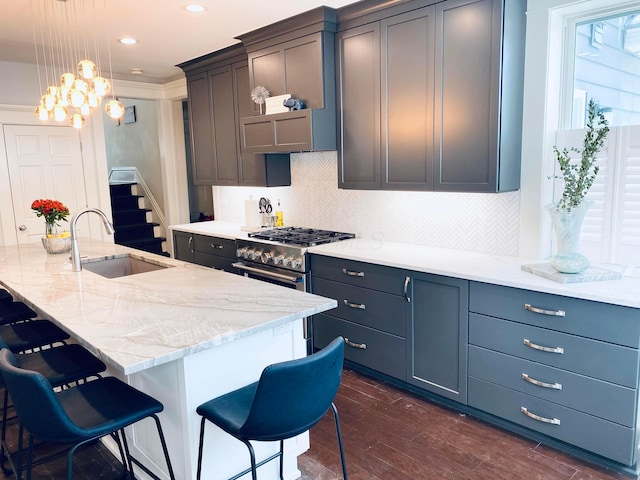 kitchen with a sink, backsplash, dark wood-style floors, and a breakfast bar