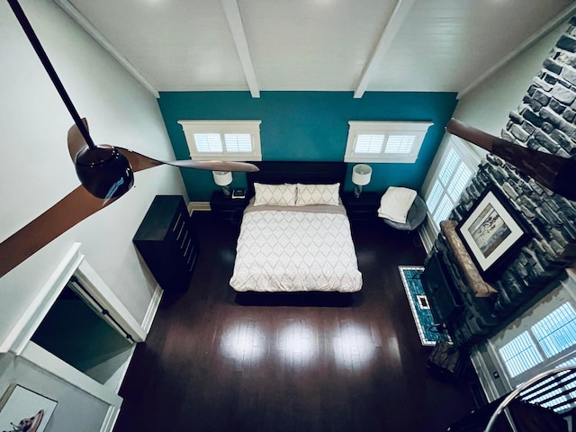 living room with baseboards, wood finished floors, and beamed ceiling