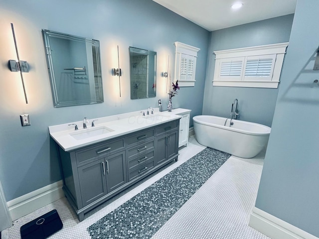 full bath with double vanity, a sink, baseboards, and a soaking tub