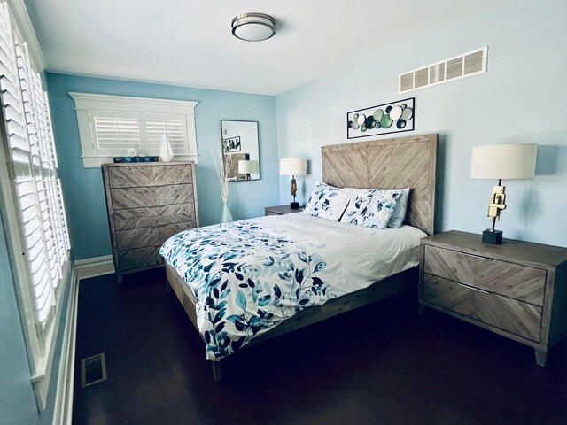 bedroom featuring baseboards and visible vents