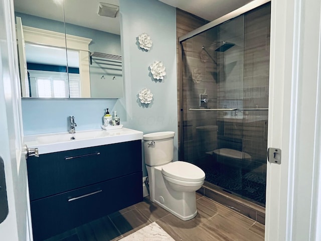 bathroom featuring vanity, toilet, and a stall shower