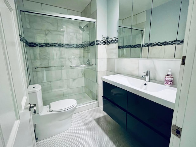 bathroom with vanity, toilet, tile walls, and a stall shower