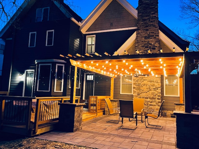rear view of property with a patio area, a pergola, and a chimney
