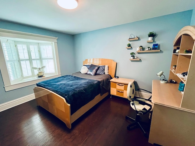 bedroom featuring baseboards and wood finished floors