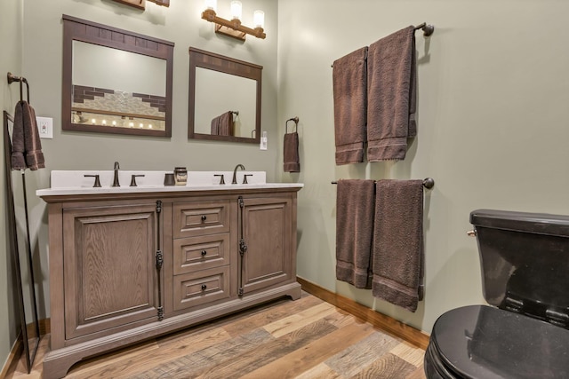 full bath with wood finished floors, toilet, and a sink