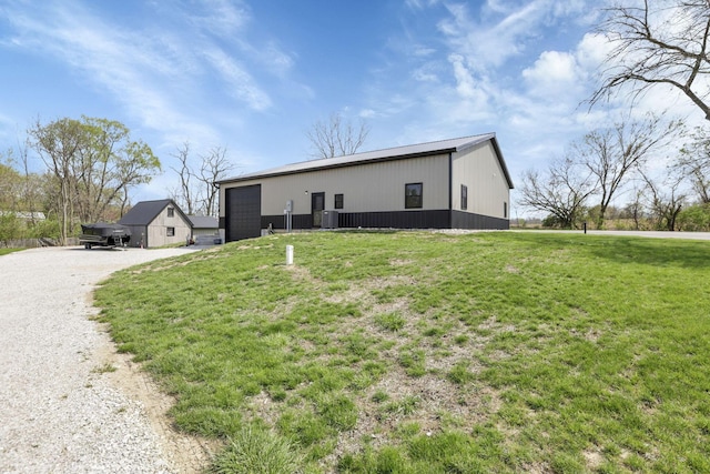 view of front of home featuring an outbuilding, a front yard, gravel driveway, and central AC
