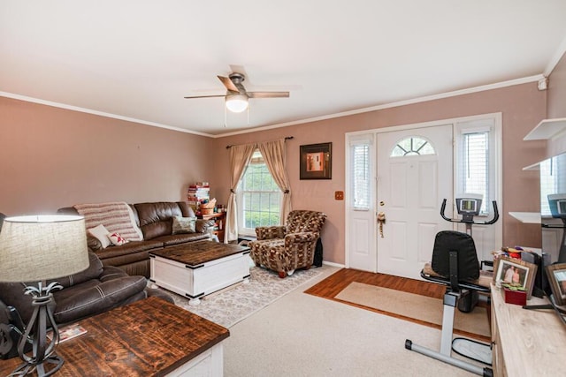 carpeted living area with baseboards, a ceiling fan, and crown molding