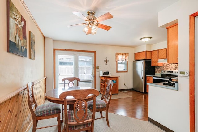 dining room featuring baseboards, ceiling fan, and dark wood-style flooring