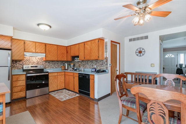 kitchen with stainless steel appliances, under cabinet range hood, tasteful backsplash, visible vents, and light countertops