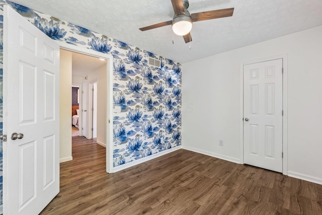 3186 Bowdoin Cir, Columbus, OH 43204 - empty room with wallpapered walls, wood finished floors, baseboards, a ceiling fan, and a textured ceiling