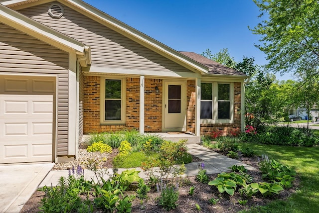 3186 Bowdoin Cir, Columbus, OH 43204 - doorway to property featuring brick siding, a garage, and driveway