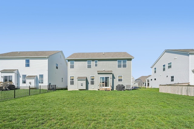 back of property with fence and a yard
