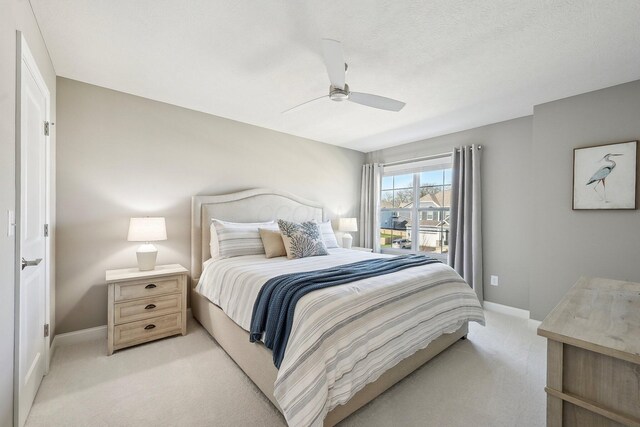 bedroom featuring baseboards, light carpet, and a ceiling fan