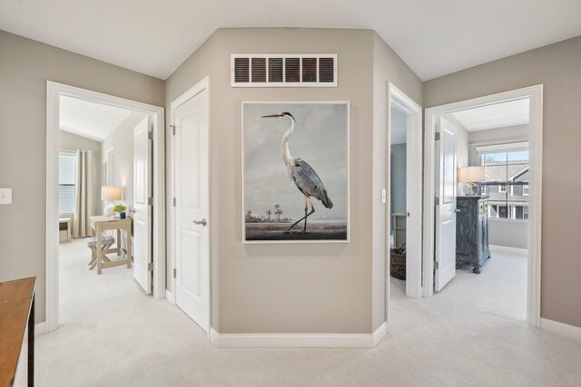 hallway featuring carpet flooring, baseboards, and visible vents