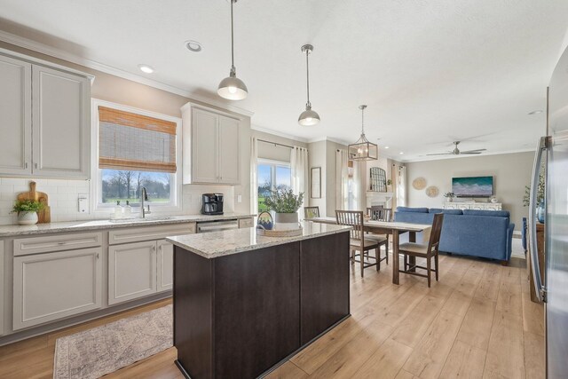 kitchen featuring ceiling fan, ornamental molding, and a sink