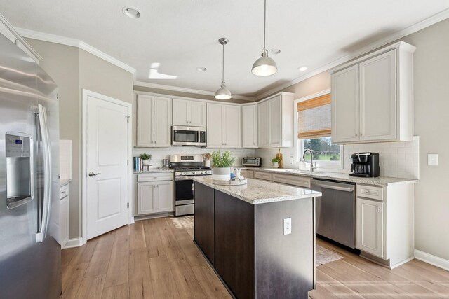 kitchen with light wood-type flooring, a sink, decorative backsplash, and stainless steel appliances