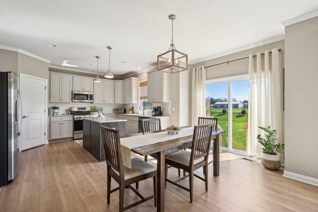dining space with crown molding, recessed lighting, and light wood finished floors