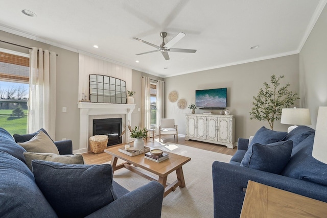 living room with crown molding, a ceiling fan, recessed lighting, and wood finished floors