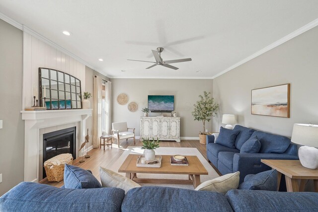 living room featuring ceiling fan, ornamental molding, and wood finished floors
