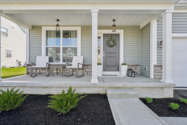 doorway to property featuring a porch and stone siding