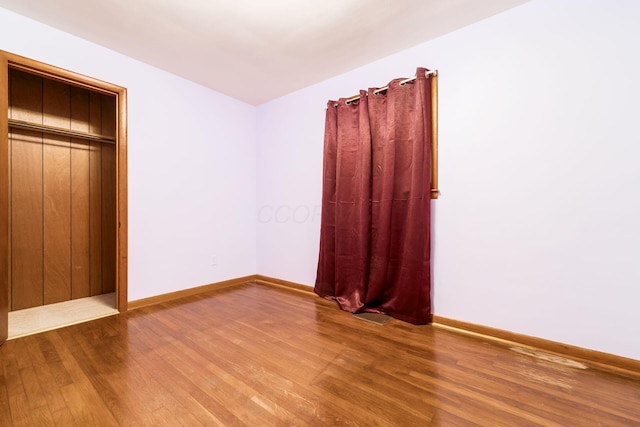 unfurnished bedroom featuring baseboards and wood finished floors