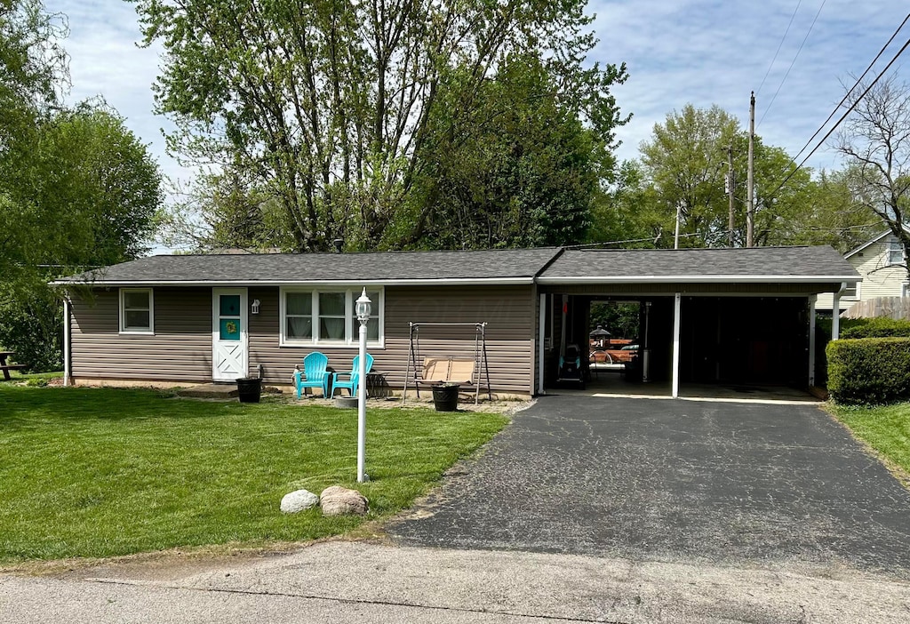 ranch-style house with an attached carport, driveway, and a front lawn