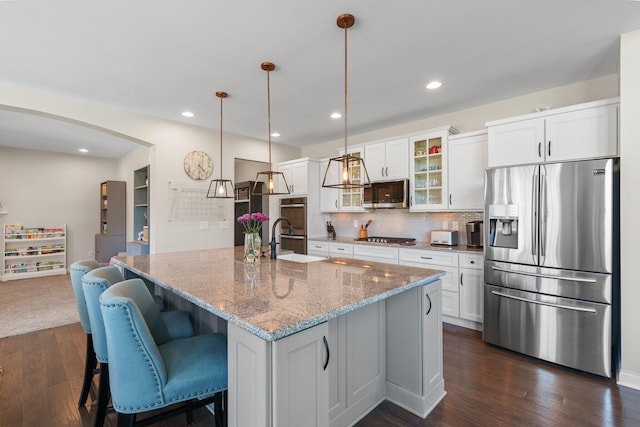 8153 Lilium Way, Plain City, OH 43064 - kitchen with glass insert cabinets, backsplash, white cabinets, appliances with stainless steel finishes, and dark wood finished floors