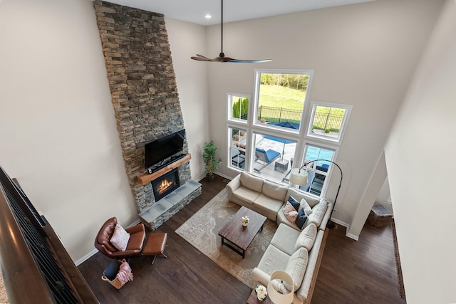 8153 Lilium Way, Plain City, OH 43064 - living area featuring wood finished floors, ceiling fan, a stone fireplace, baseboards, and a high ceiling
