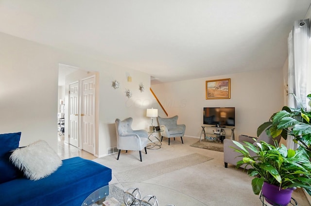carpeted living room with visible vents and baseboards