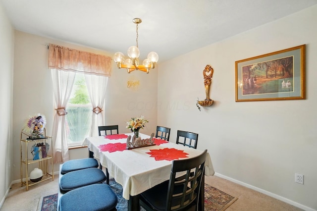 dining area with a chandelier, baseboards, and light carpet