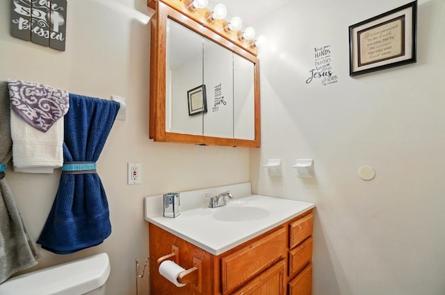 half bathroom with vanity and toilet