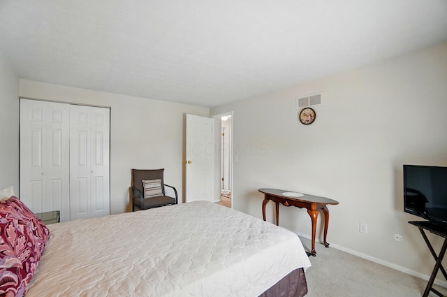 carpeted bedroom with a closet, visible vents, and baseboards