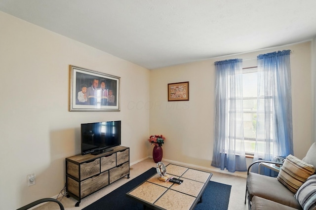 living area featuring carpet flooring, baseboards, and a healthy amount of sunlight