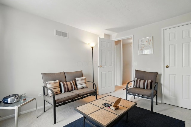 living area with baseboards, visible vents, and light carpet
