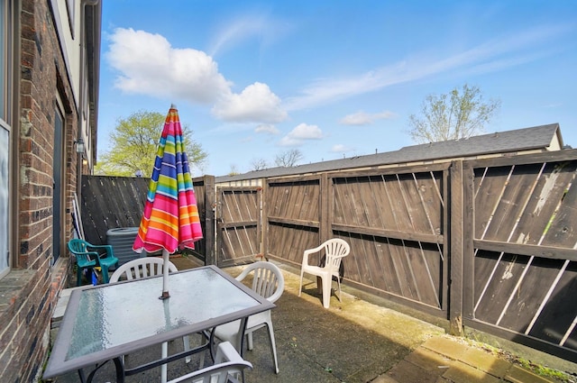 view of patio with a fenced backyard, central AC unit, and outdoor dining area
