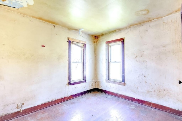 spare room featuring baseboards and concrete floors