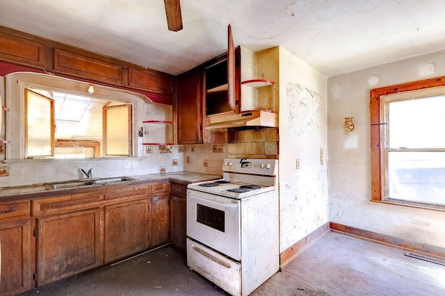 kitchen with brown cabinets, white range with electric stovetop, open shelves, a sink, and under cabinet range hood