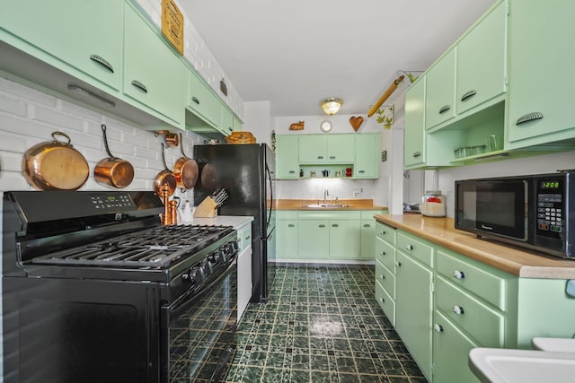 kitchen featuring a sink, open shelves, tasteful backsplash, black appliances, and green cabinetry