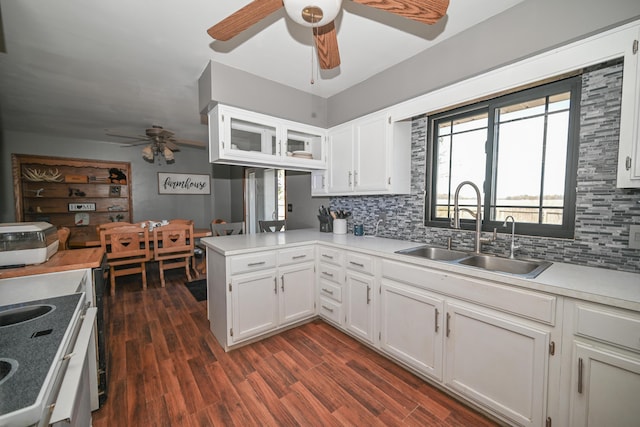 kitchen with decorative backsplash, ceiling fan, a sink, a peninsula, and white cabinetry